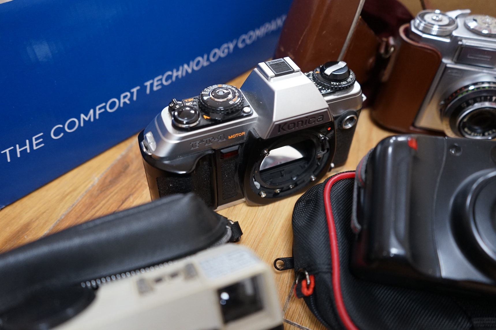A collection of various cameras and camera equipment to include Konica